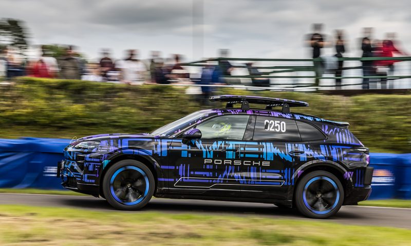Camoflagued Porsche Cayenne Electric competing at the Shelsley Walsh hill climb left side view.
