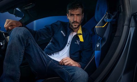 Model sitting in a car wearing clothes from the Sparco X Maserati fan collection.
