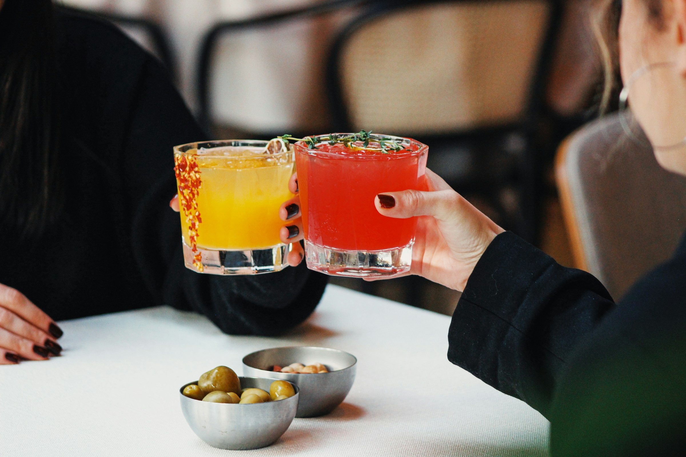 Two people toasting with cocktails