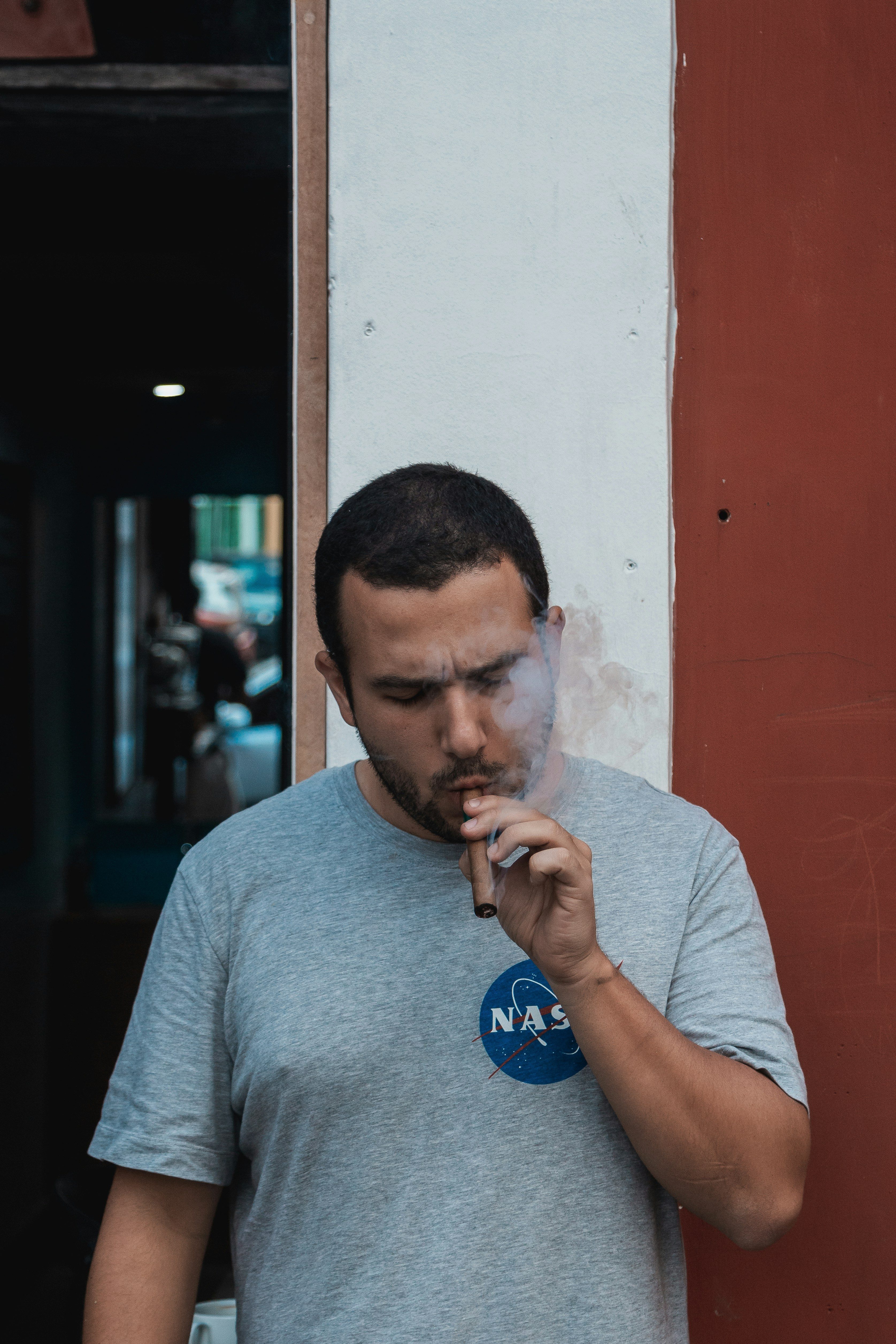 man-in gray crew neck t-shirt smoking cigar