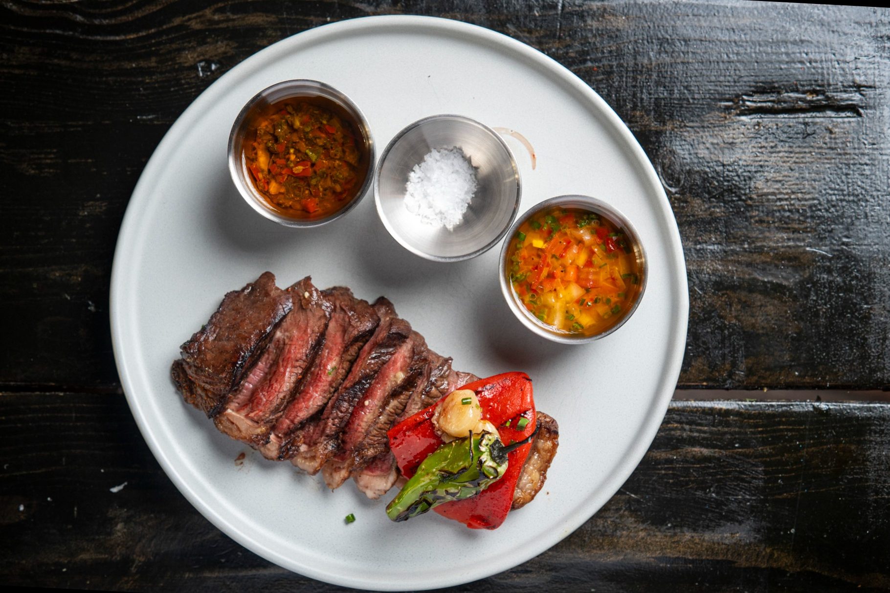 picanha steak with sauces on white plate