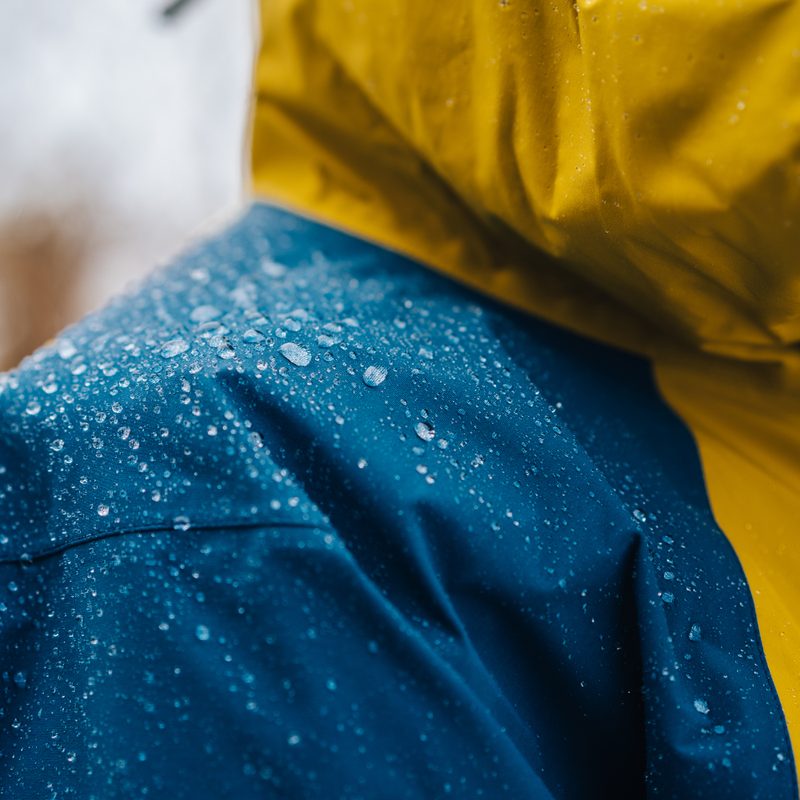 Detail photo of wateproof jacket with water droplets on it. Jacket using the gore-tex technology