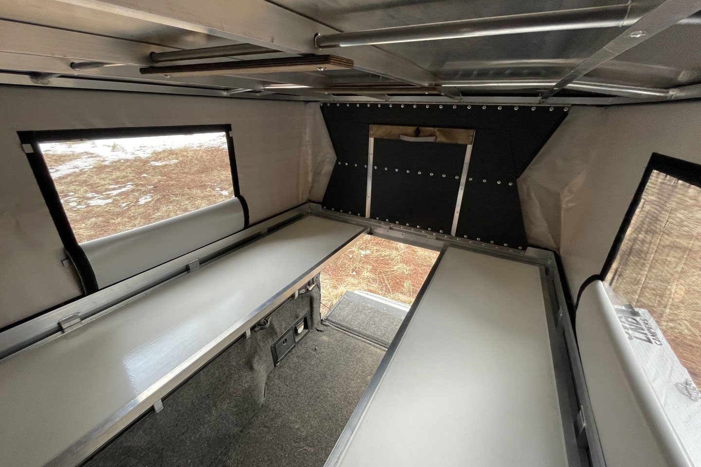 Wide interior of Ovrlnd Campers' Bivy Chubby truck camper package.