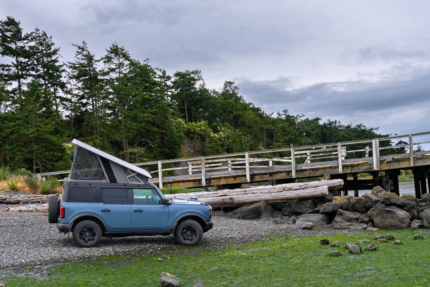 Profile of a blue Ford Bronco with Ursa Minor's B30 rooftop tent camper installed.