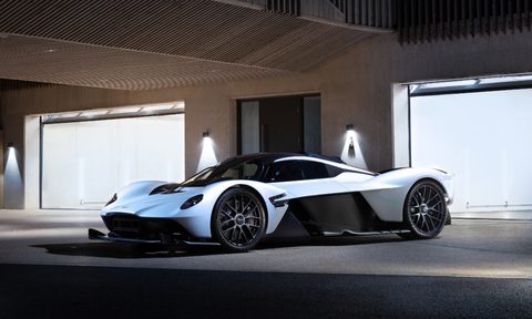 Daniel Ricciardo Aston Martin Valkyrie left front three quarter view parked in front of a garage door.