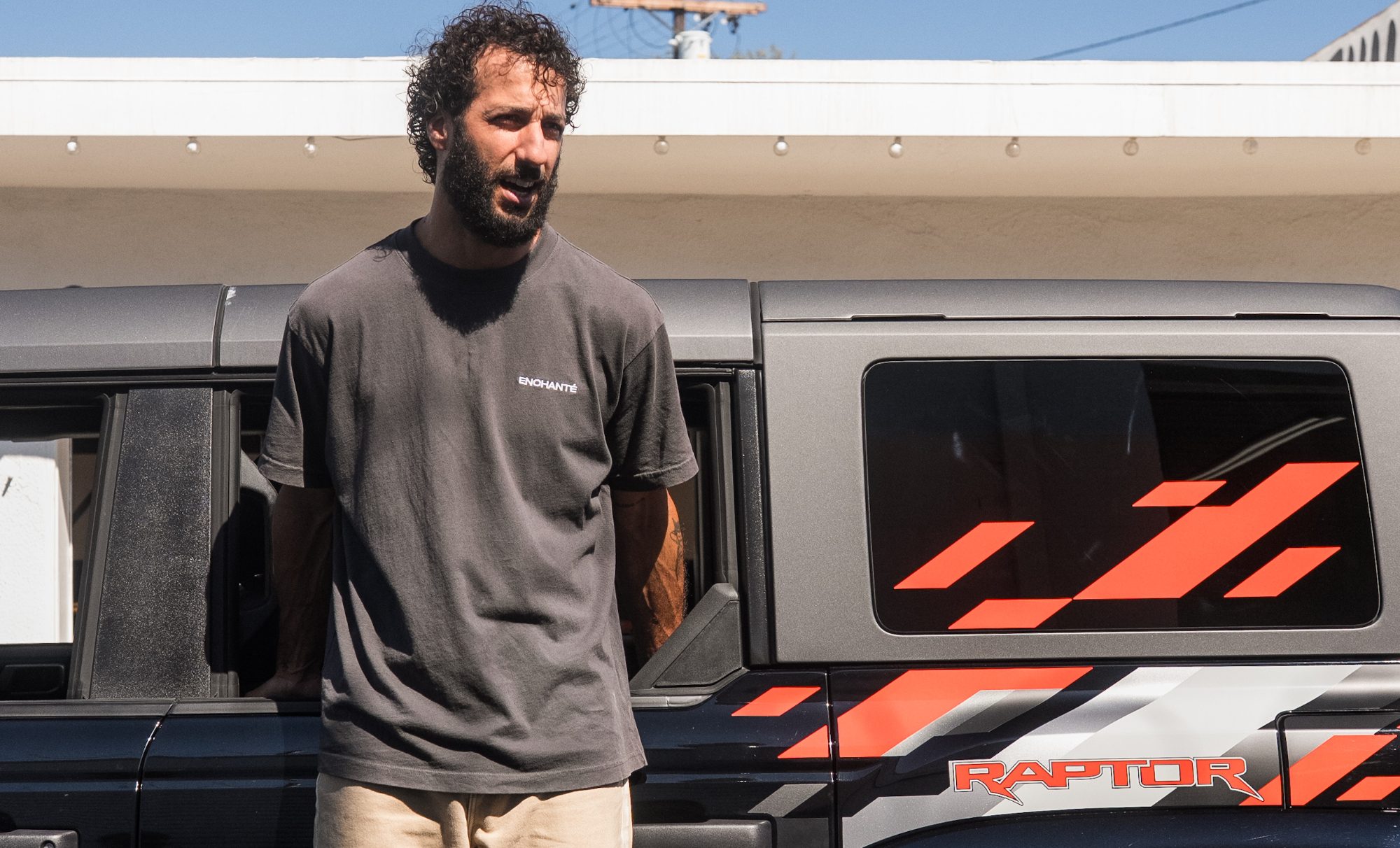 Daniel Ricciardo standing next to a Ford Bronco Raptor.