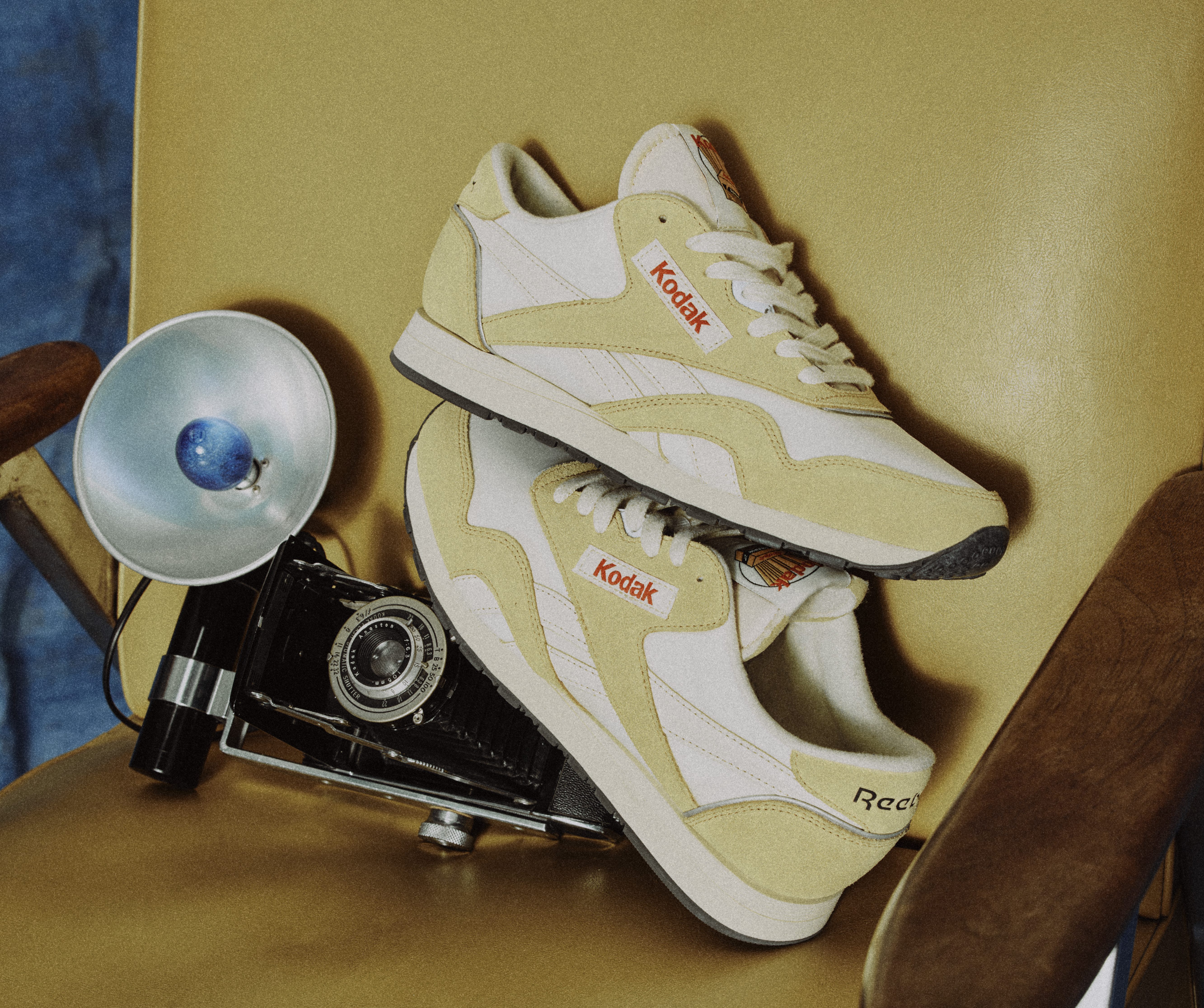 reebok sneakers next to film camera