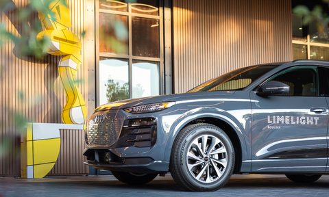 Gray Audi SUV with Boulder Limelight hotel logo parked next to hotel entrance left side front view.