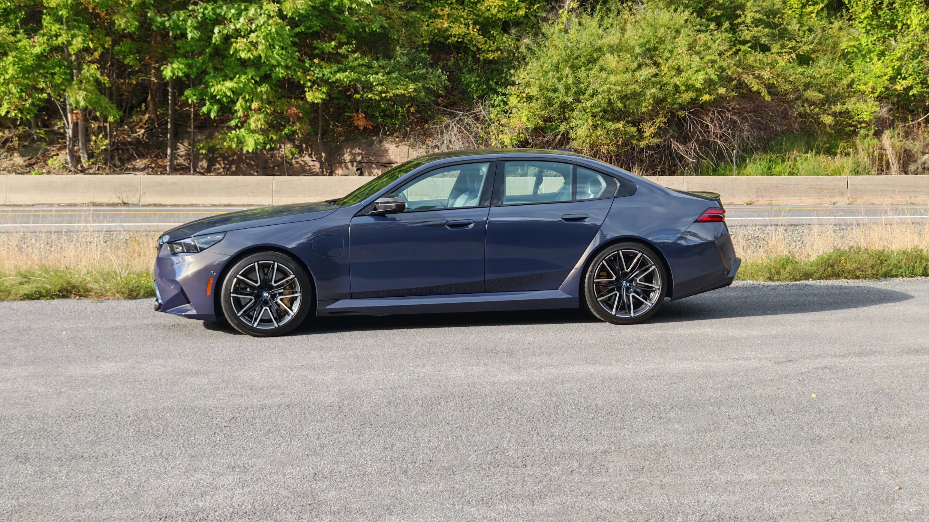 Side view of a a 2025 BMW M5 in the countryside