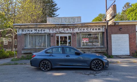 BMW M340i side view parked in front of a dilapidated ice cream shop