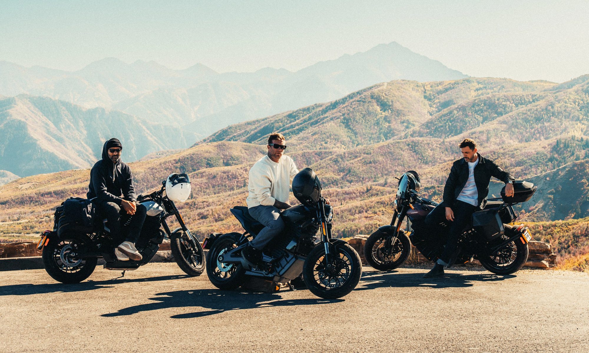 Three riders parked on the roadside with LiveWire S2 Alpinistas with mountains in the background.