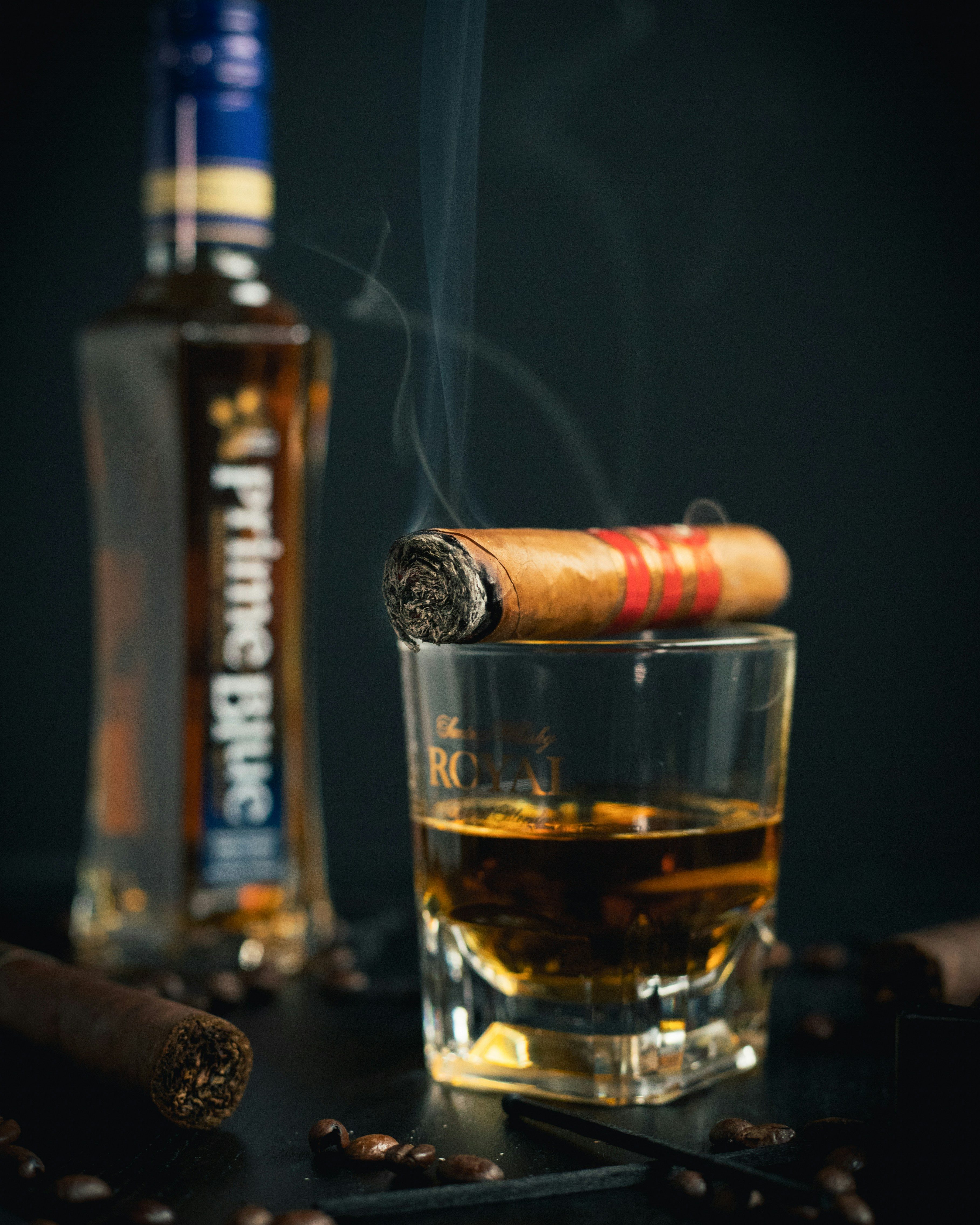 a cigar resting on a drinking glass