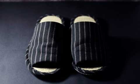 black house slippers on dark floors
