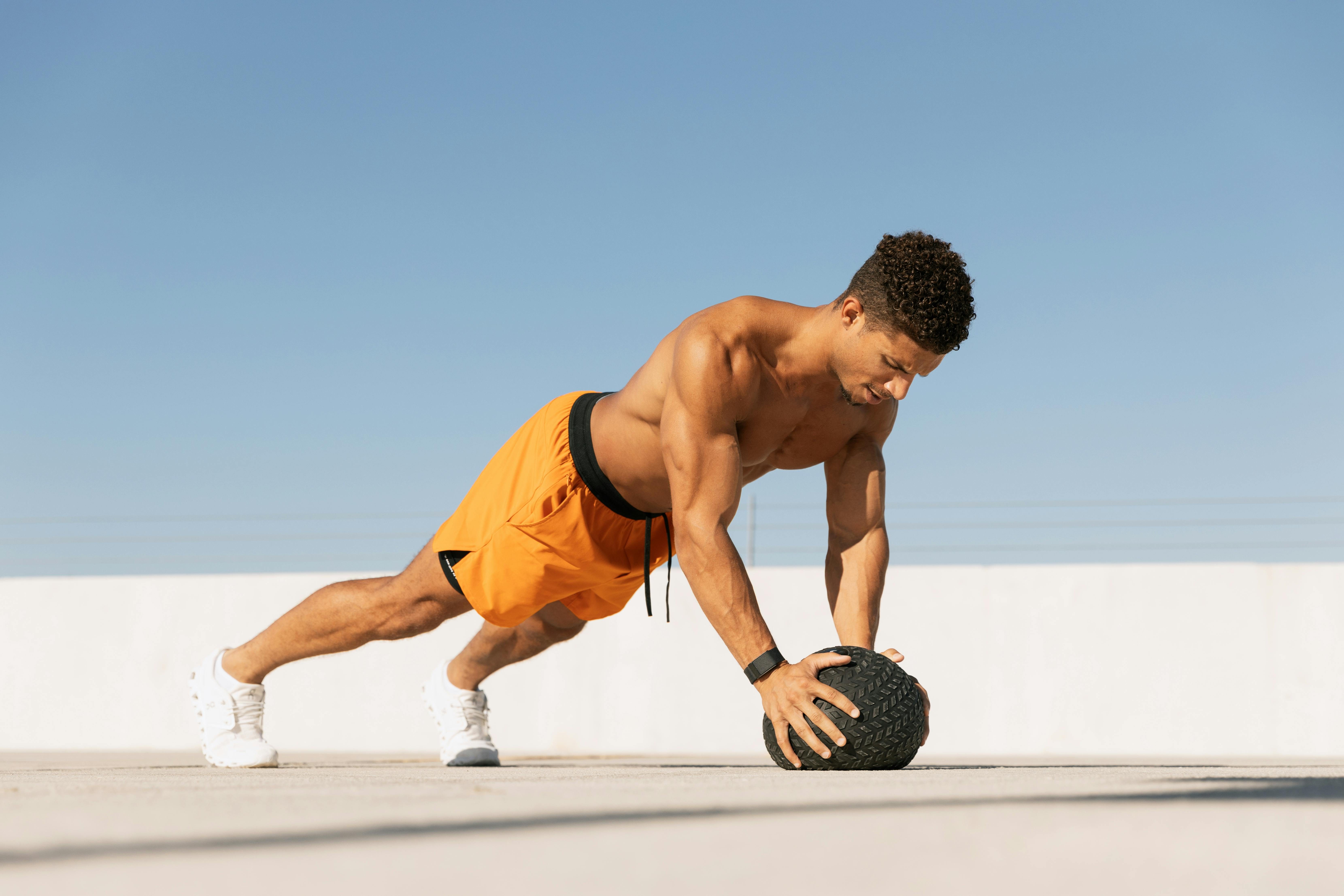 Man doing push-up on medicine ball.