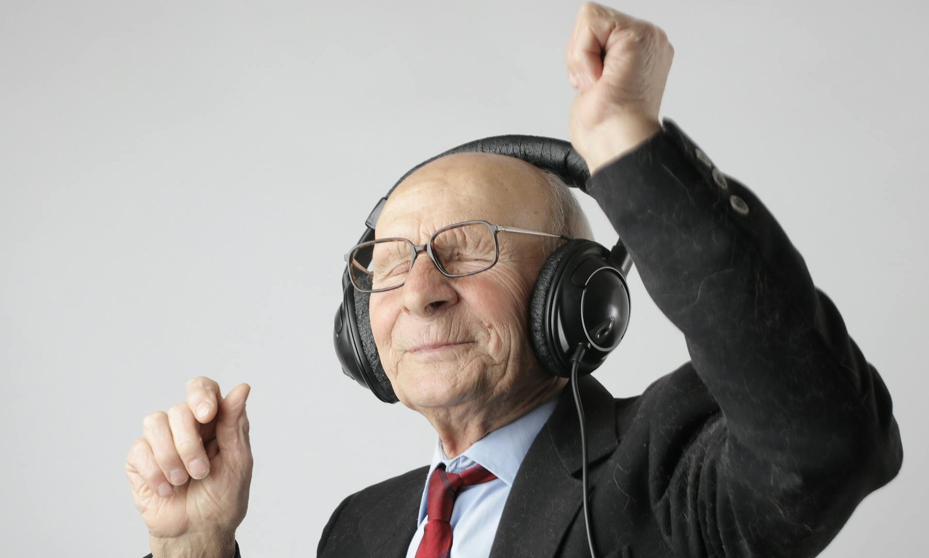 older man dancing headphones on