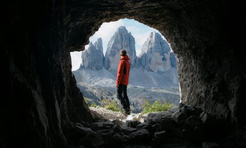 photo looking at a man through the opening of a cave