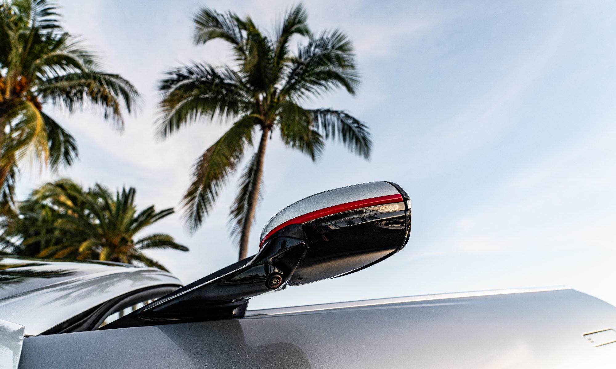 Driver side mirror with red turn indicator light on yacht-inspired Aston Martin Vanquish duo.