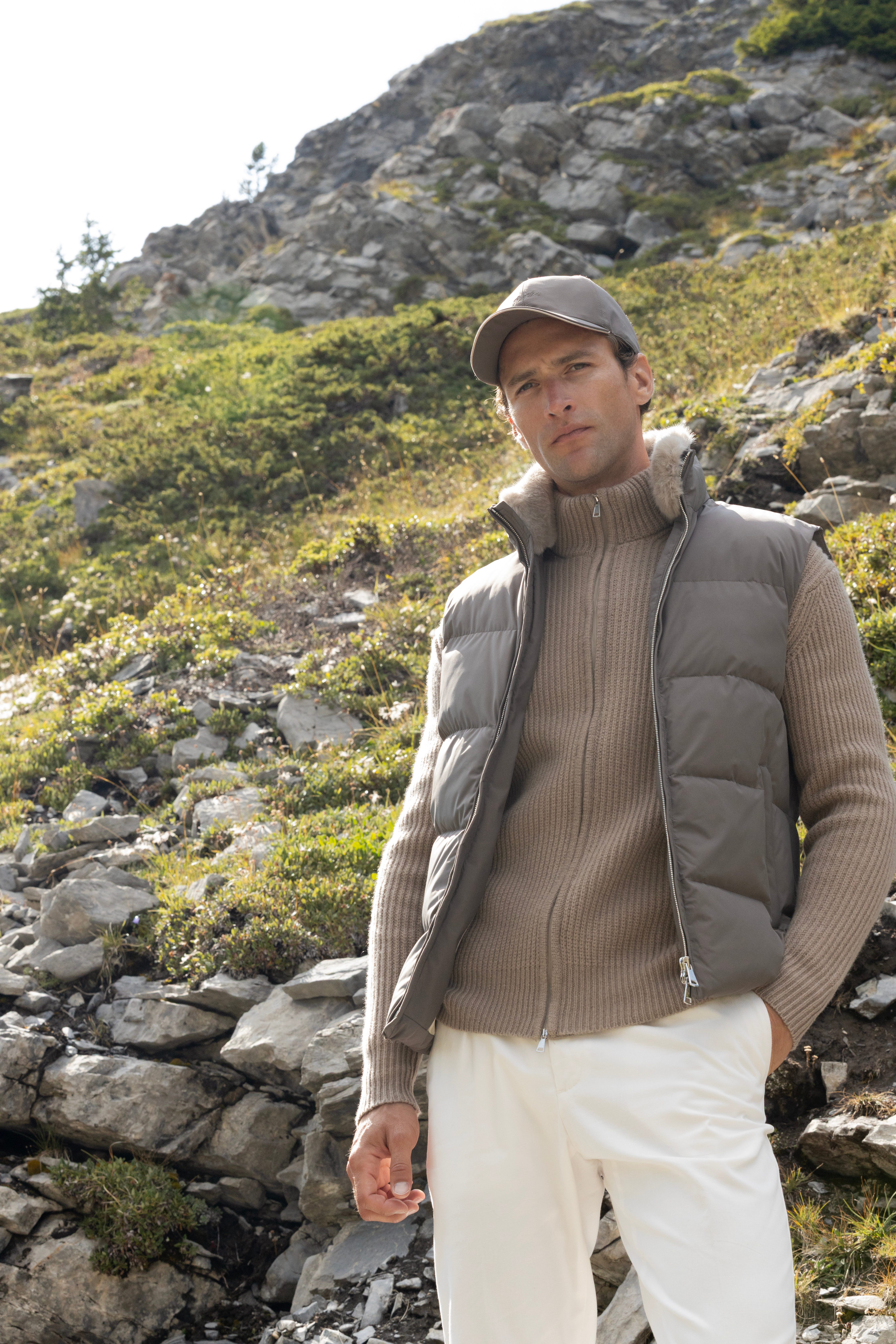 Man standing on mountain top in puffer vest
