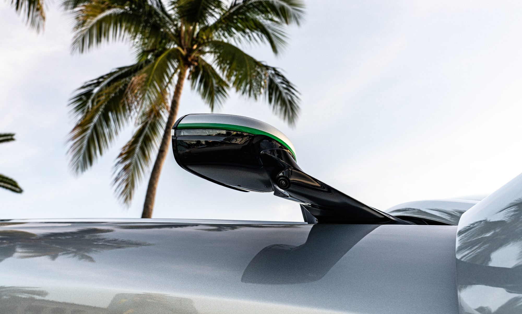 Driver side mirror with red turn indicator light on yacht-inspired Aston Martin Vanquish duo.