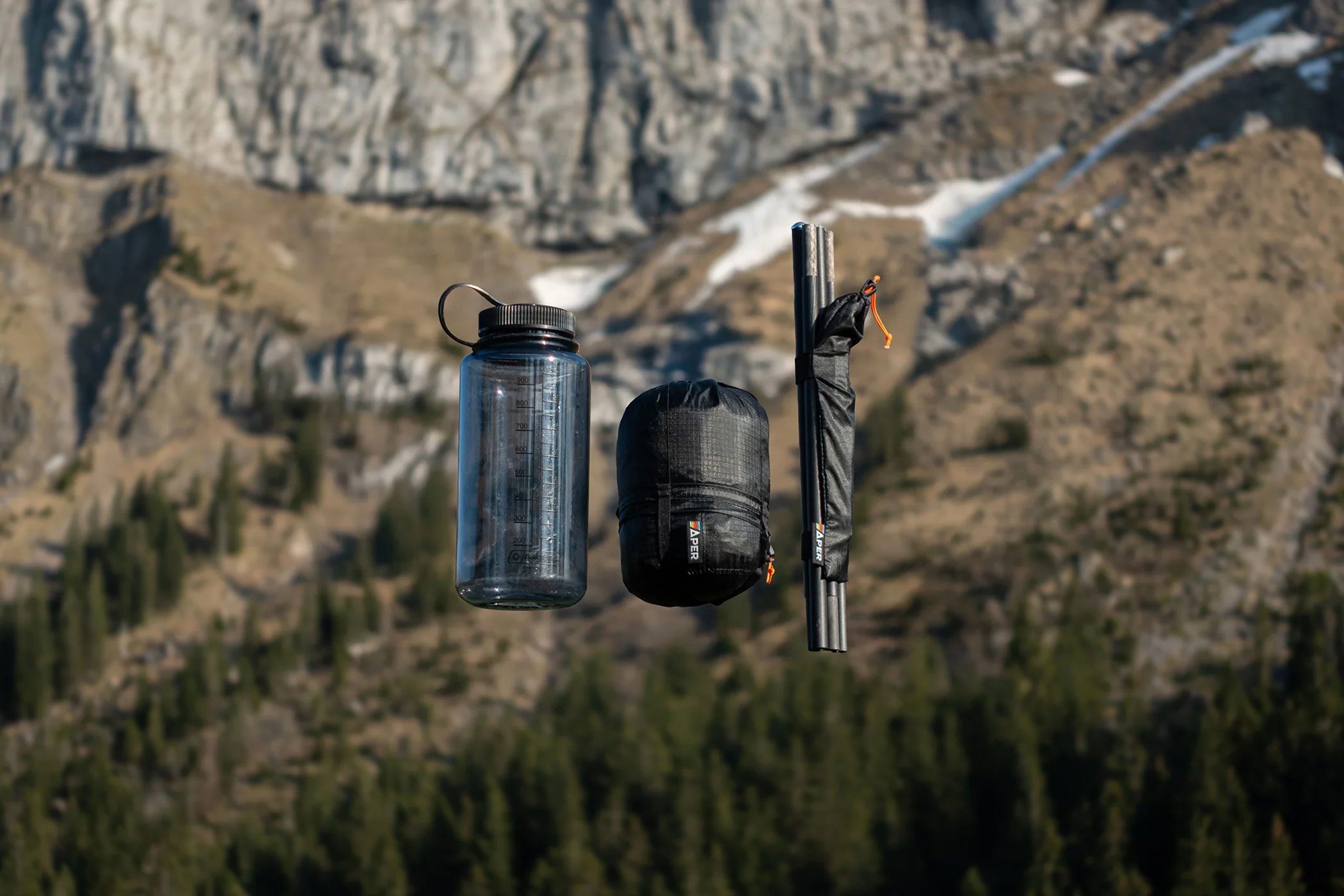 The scale of Aper's Apex1 bikepacking tent compared to a traditional one-liter Nalgene water bottle.