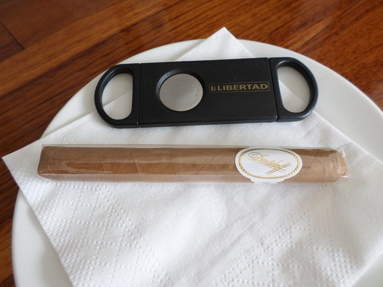 a cigar and a cutter on a napkin