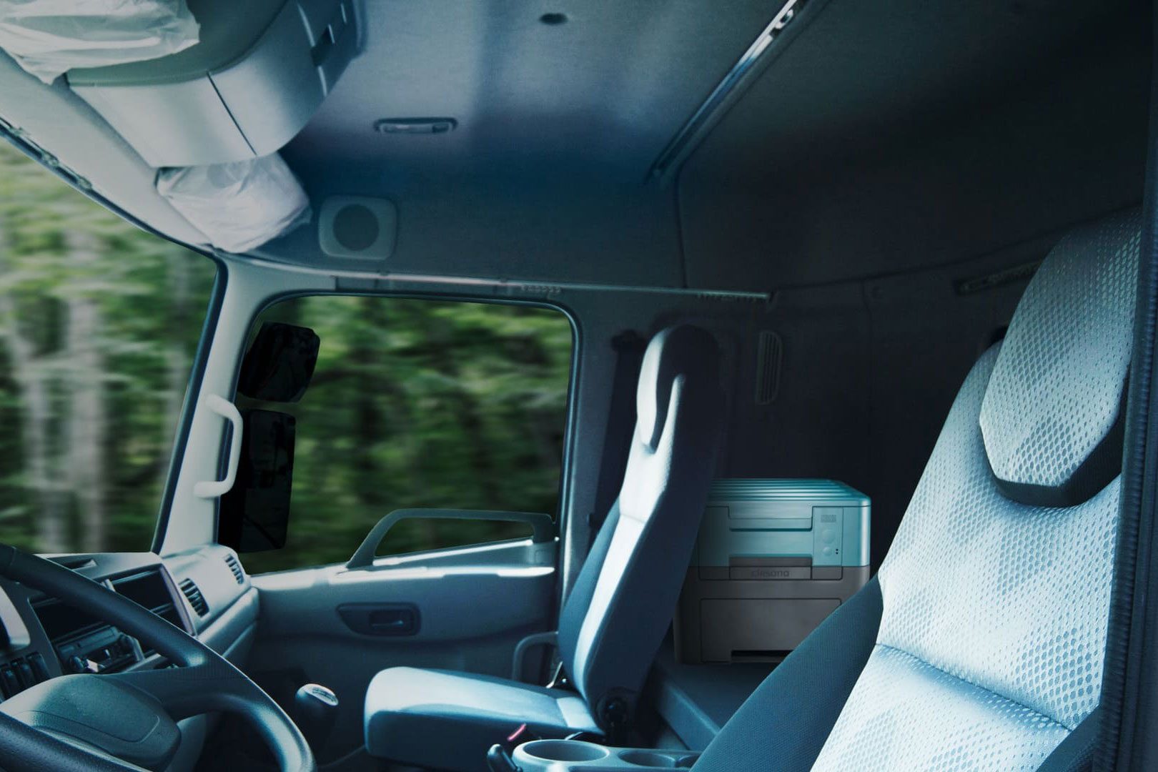 Clesana's X1 portable toilet tucked behind the front seat of a van.