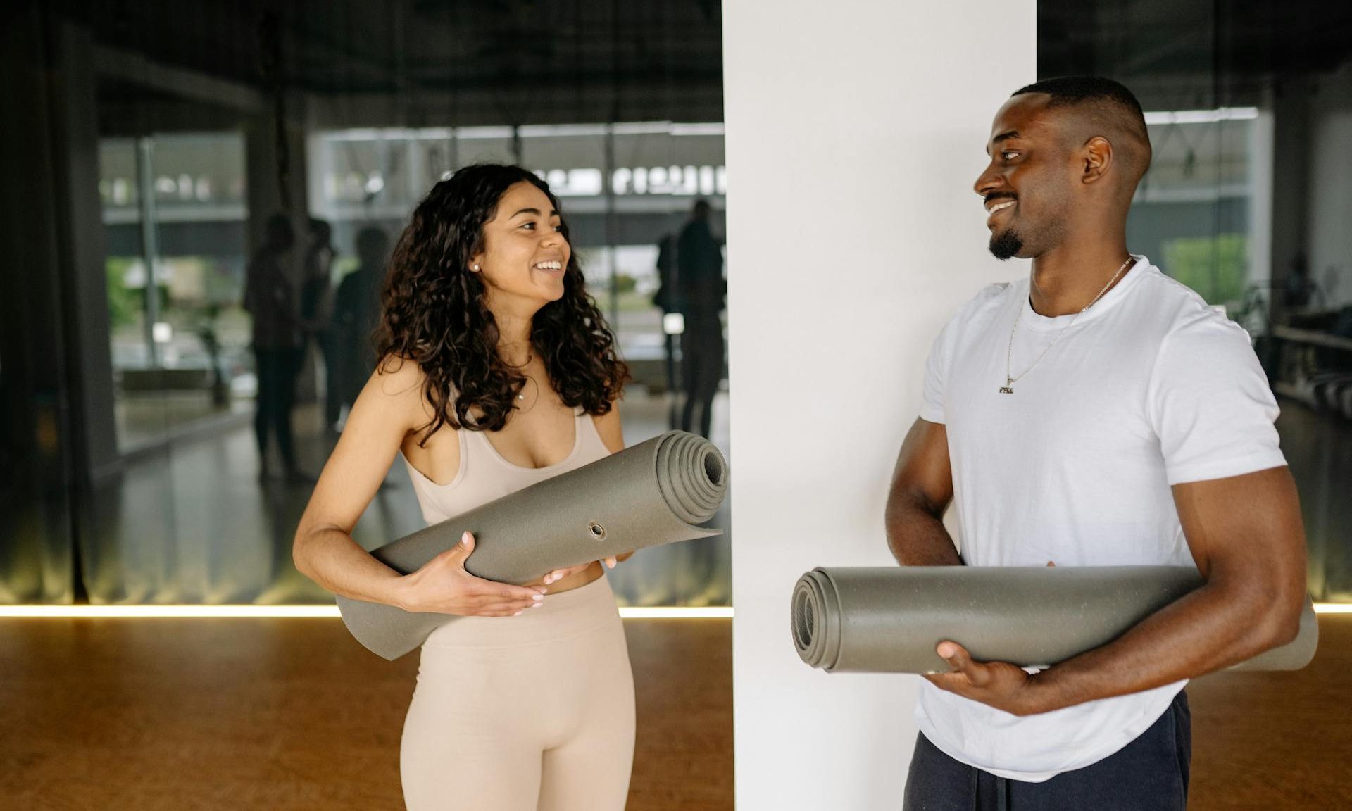 man and woman talking holding yoga mat workout mat