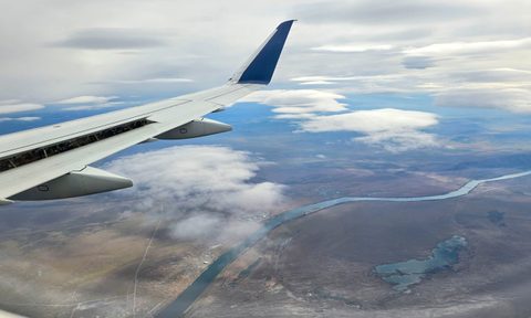 A wing of an airplane mid flight