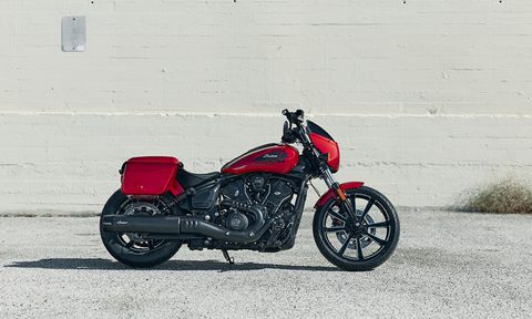 2026 Indian Sport Scout RT right profile shot parked in front of a white concrete block wall.