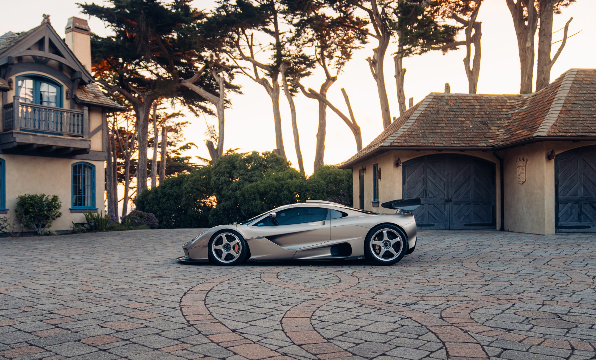 Gordon Murray S1 LM supercar parked on a stone drive courtyard left profile view.