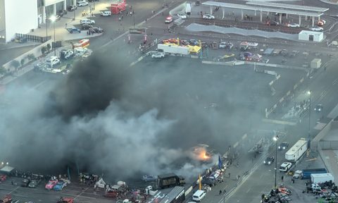 Aerial view of SEMA's HorsePower Rodeo with a large plume of black smoke and a car's tires visibly burning