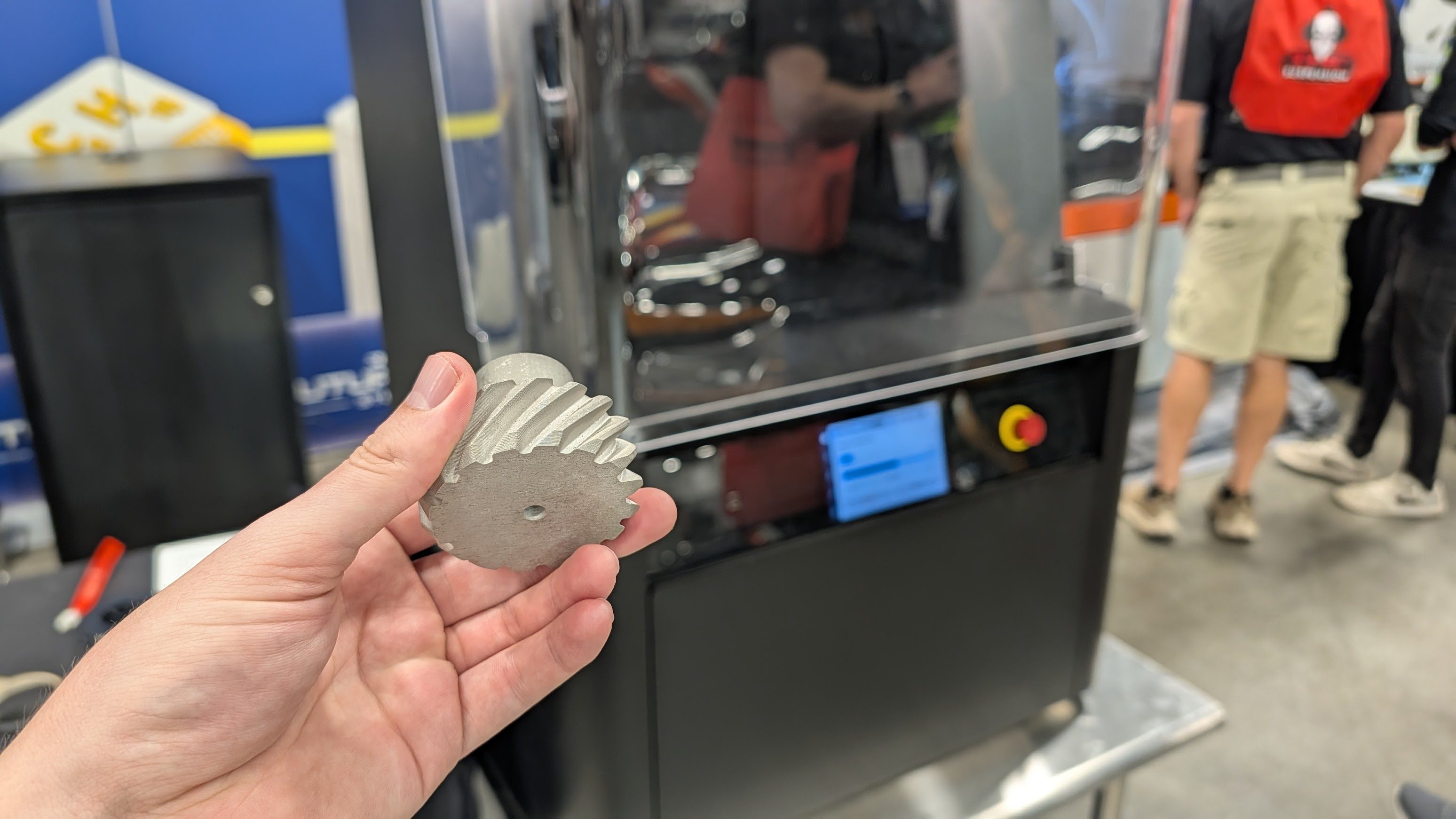 A 3D printed part in front of a 3D Metal Printer