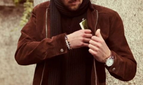 A premium brown suede jacket paired with a luxury watch, and jewelry as holiday gifts