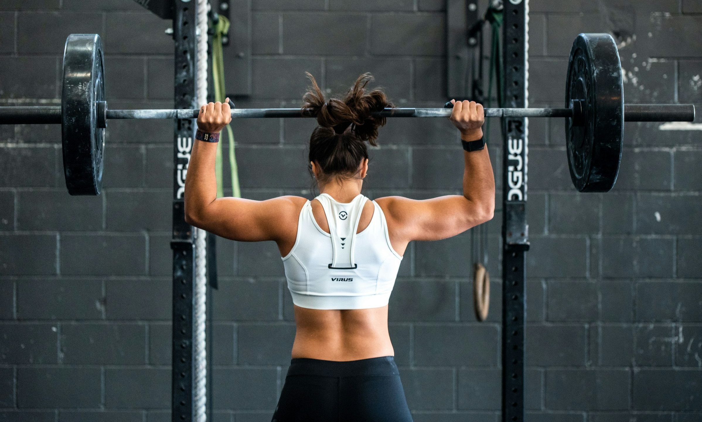 woman doing barbell push press in the gym