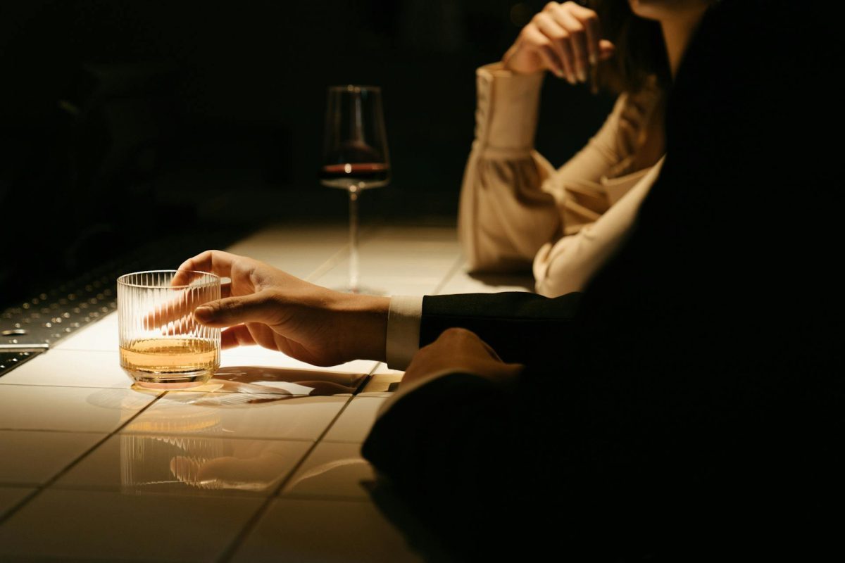 a man at a bar with a cocktail
