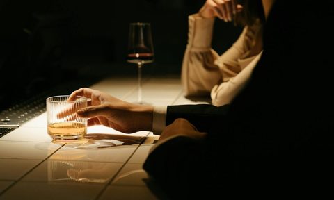 a man at a bar with a cocktail