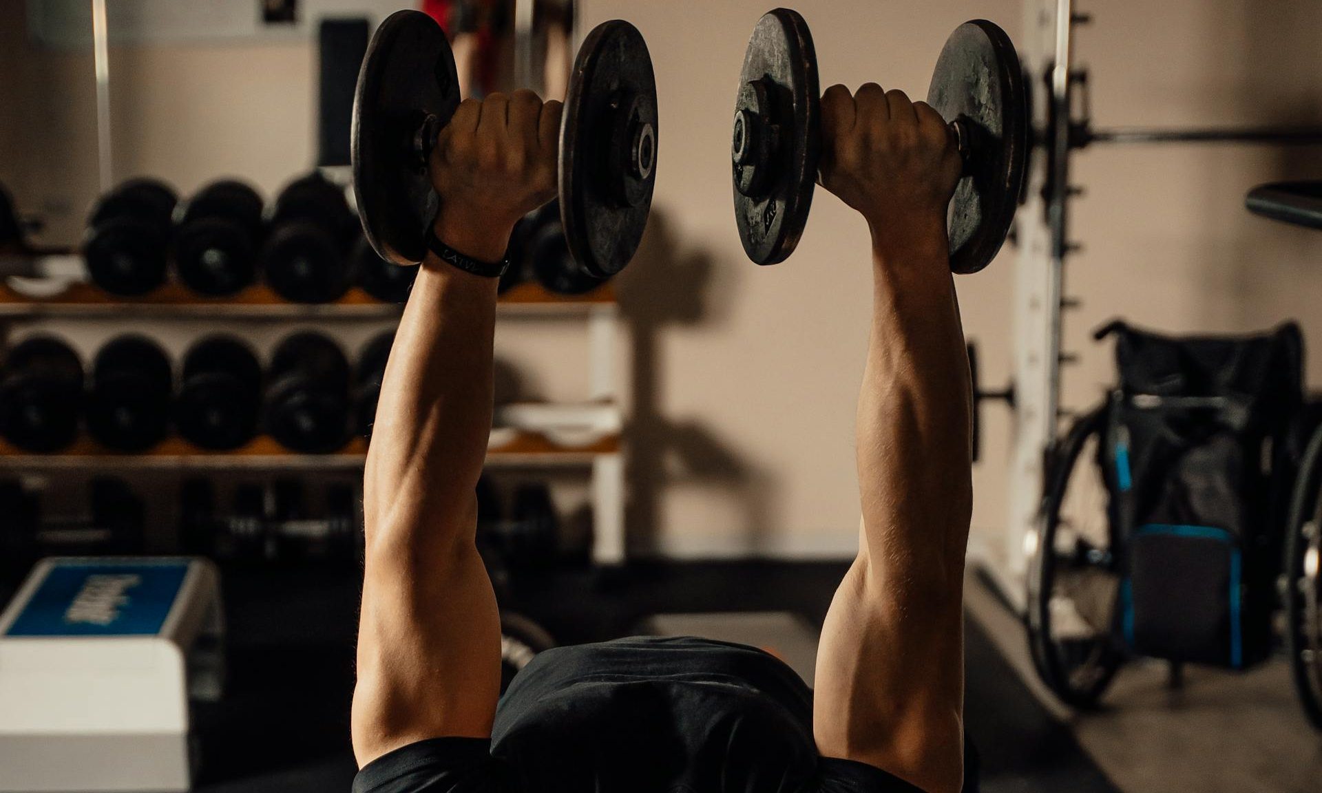 man chest press dumbbells gym bench