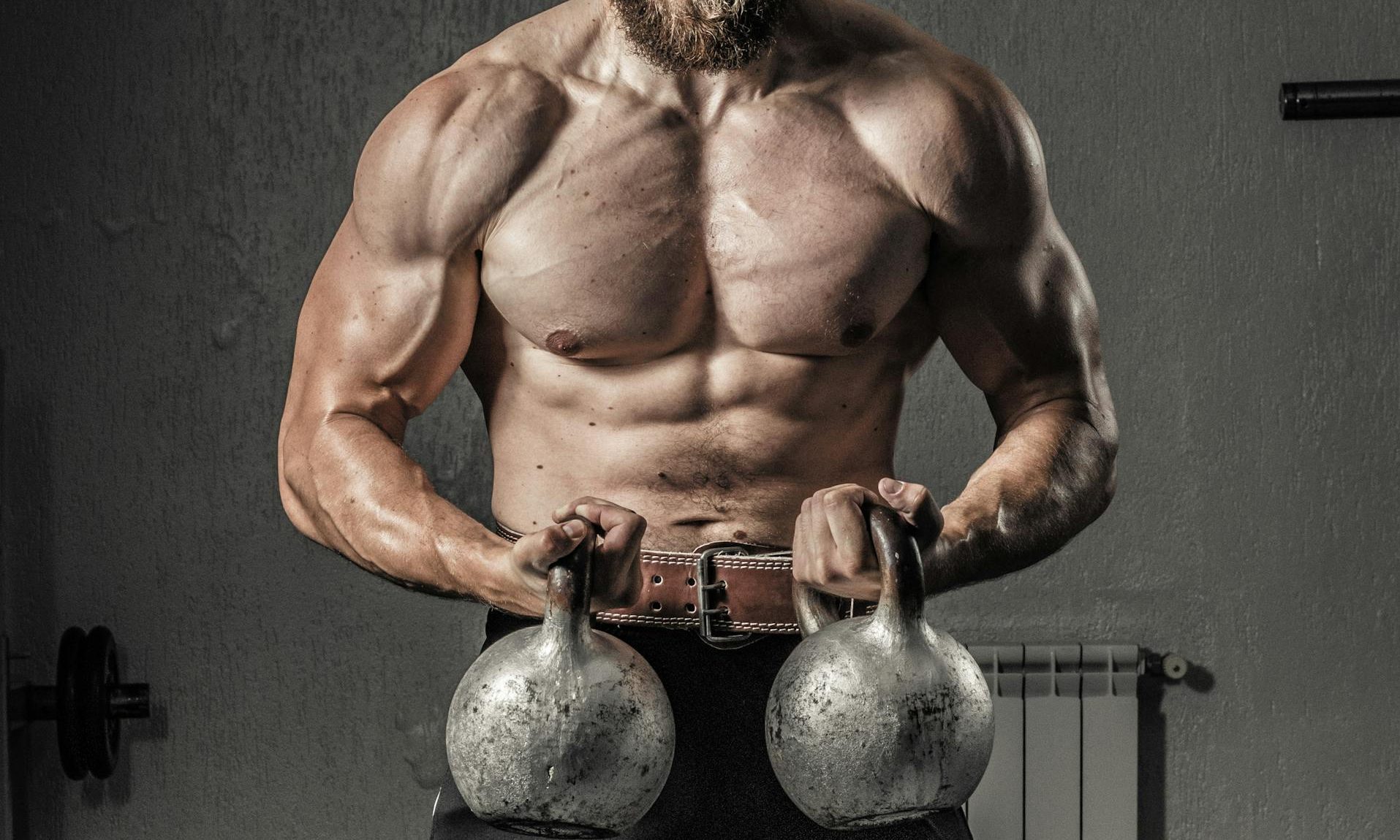 man lifting kettlebells weightlifting in gym