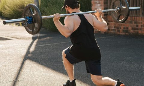 man doing reverse lunge barbell workout split squat
