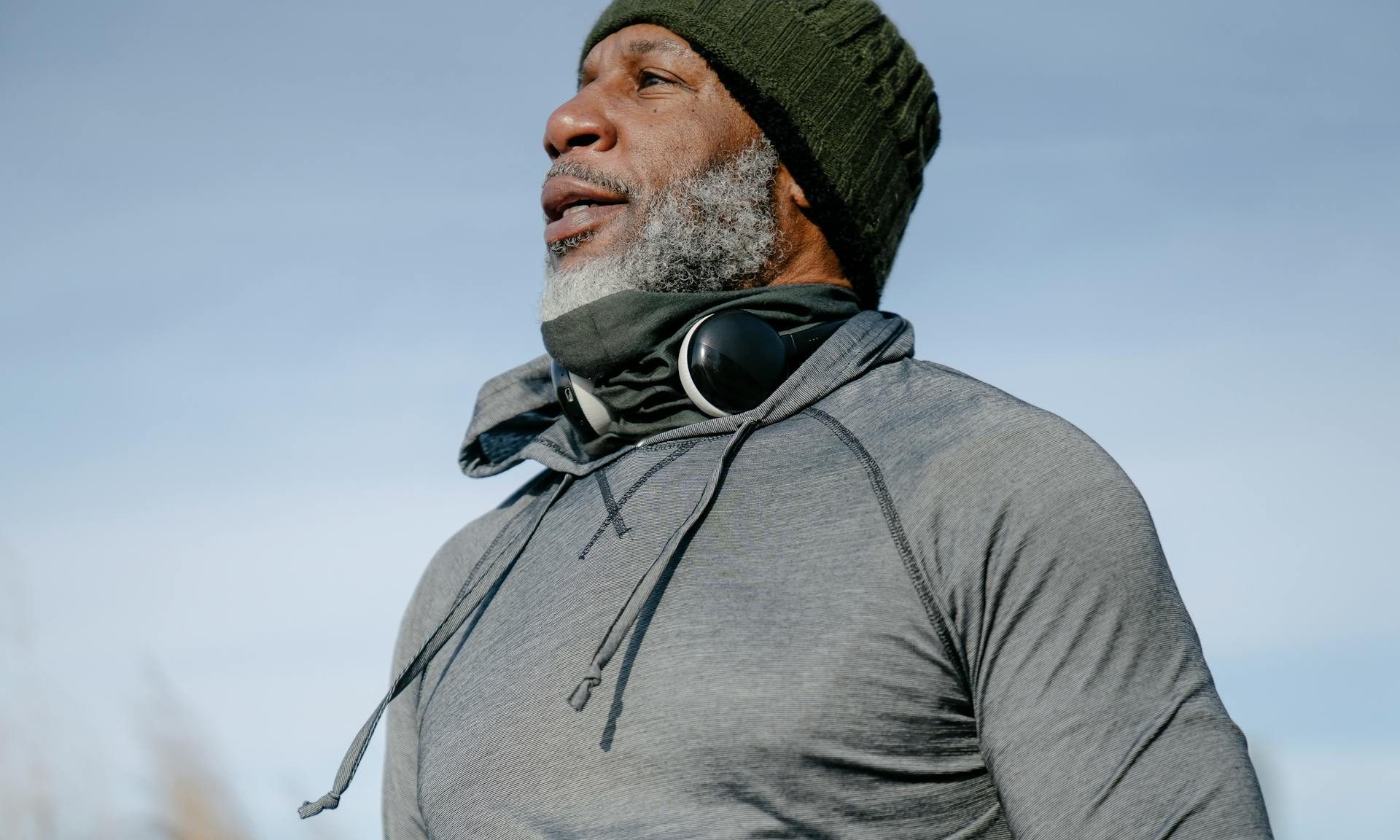 older man walking outside headphones