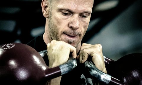 man weight training with kettlebells weightlifting