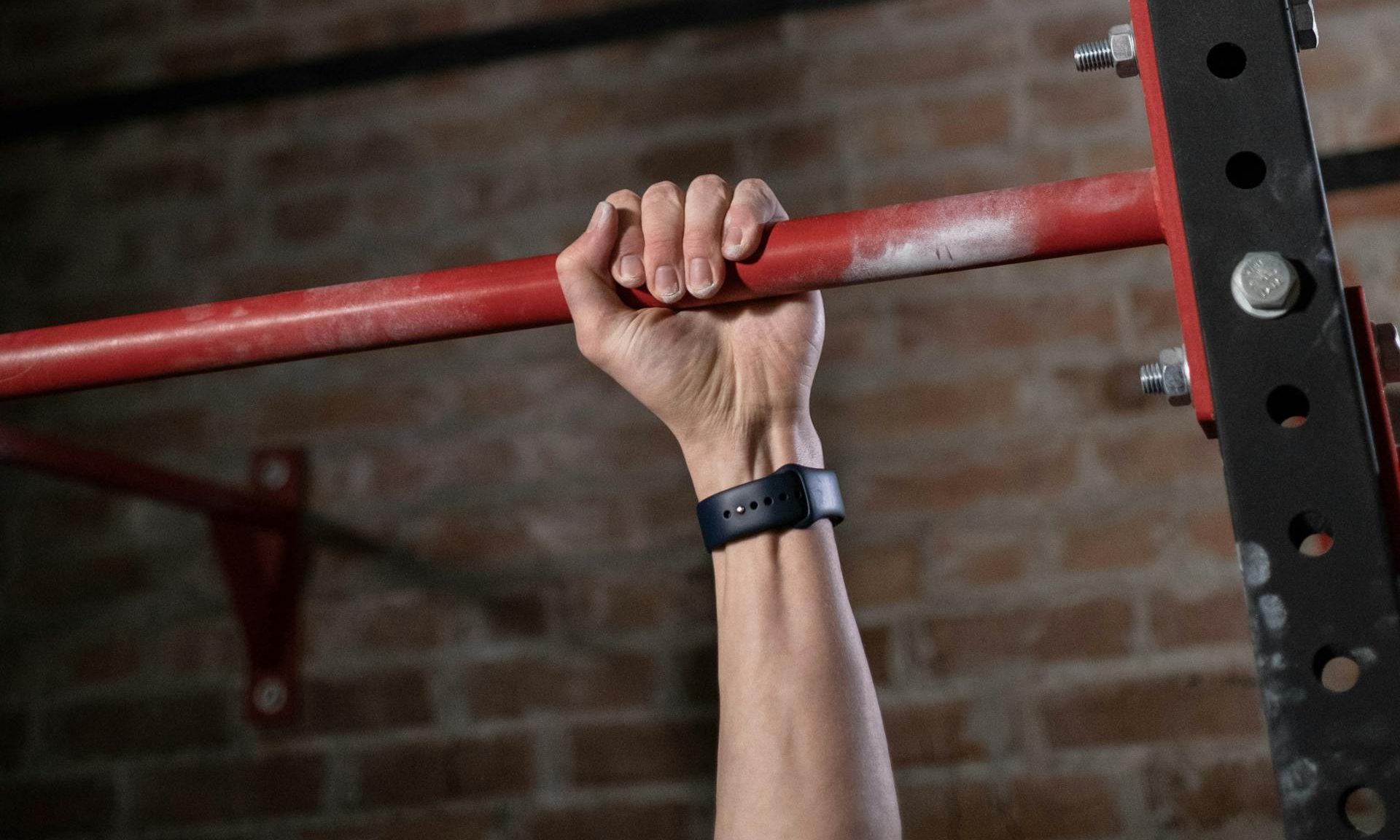 man gripping bar grip strength dead hang
