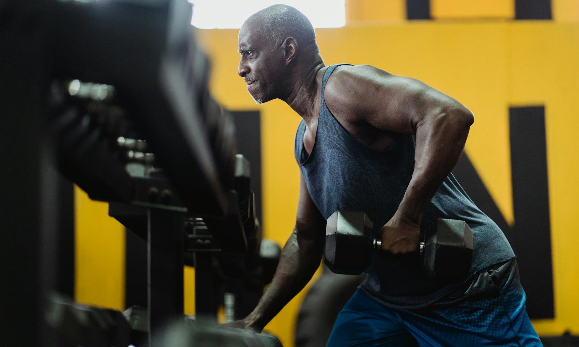 man lifting weights in gym dumbbell