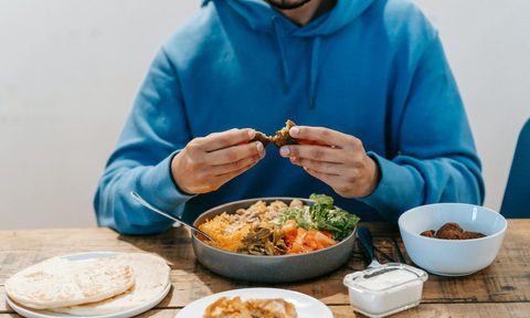 man eating meat at dinner