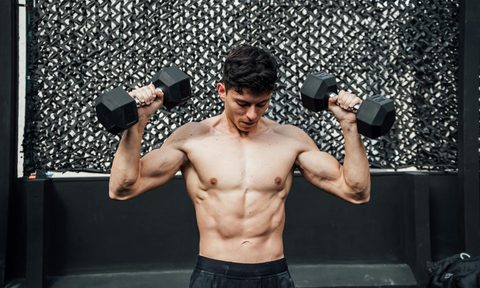 man lifting dumbbells in gym