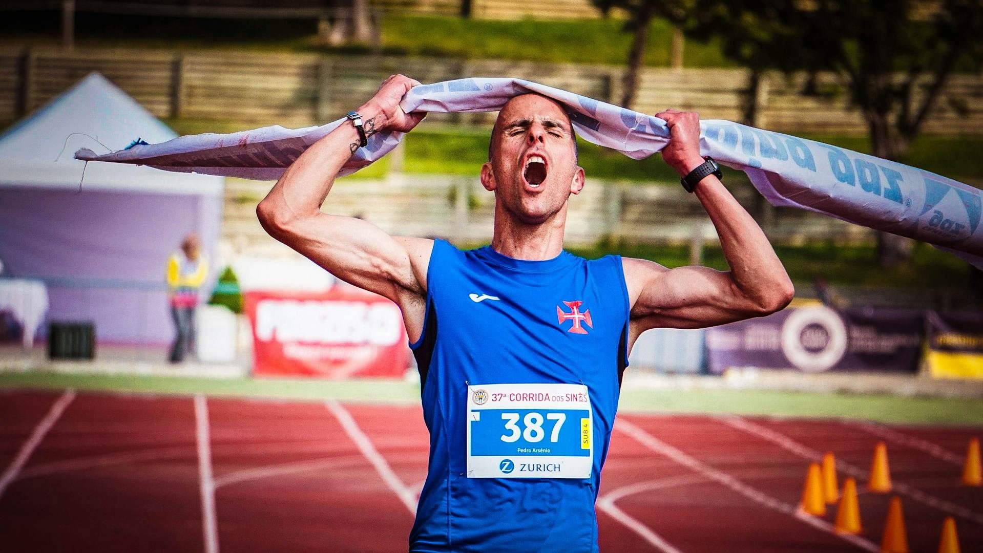 man crossing finish line running marathon