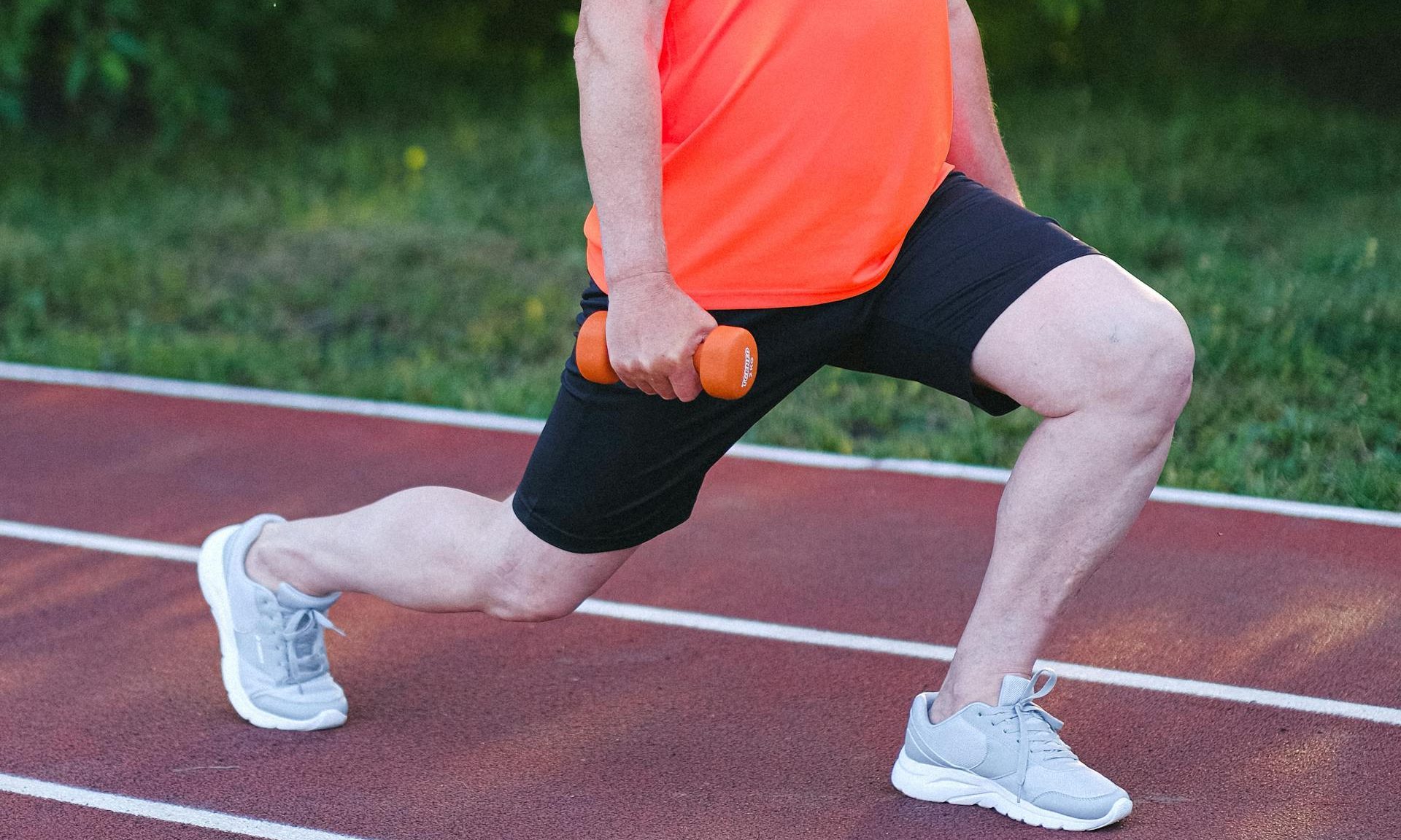 man doing dumbbell lunge outside
