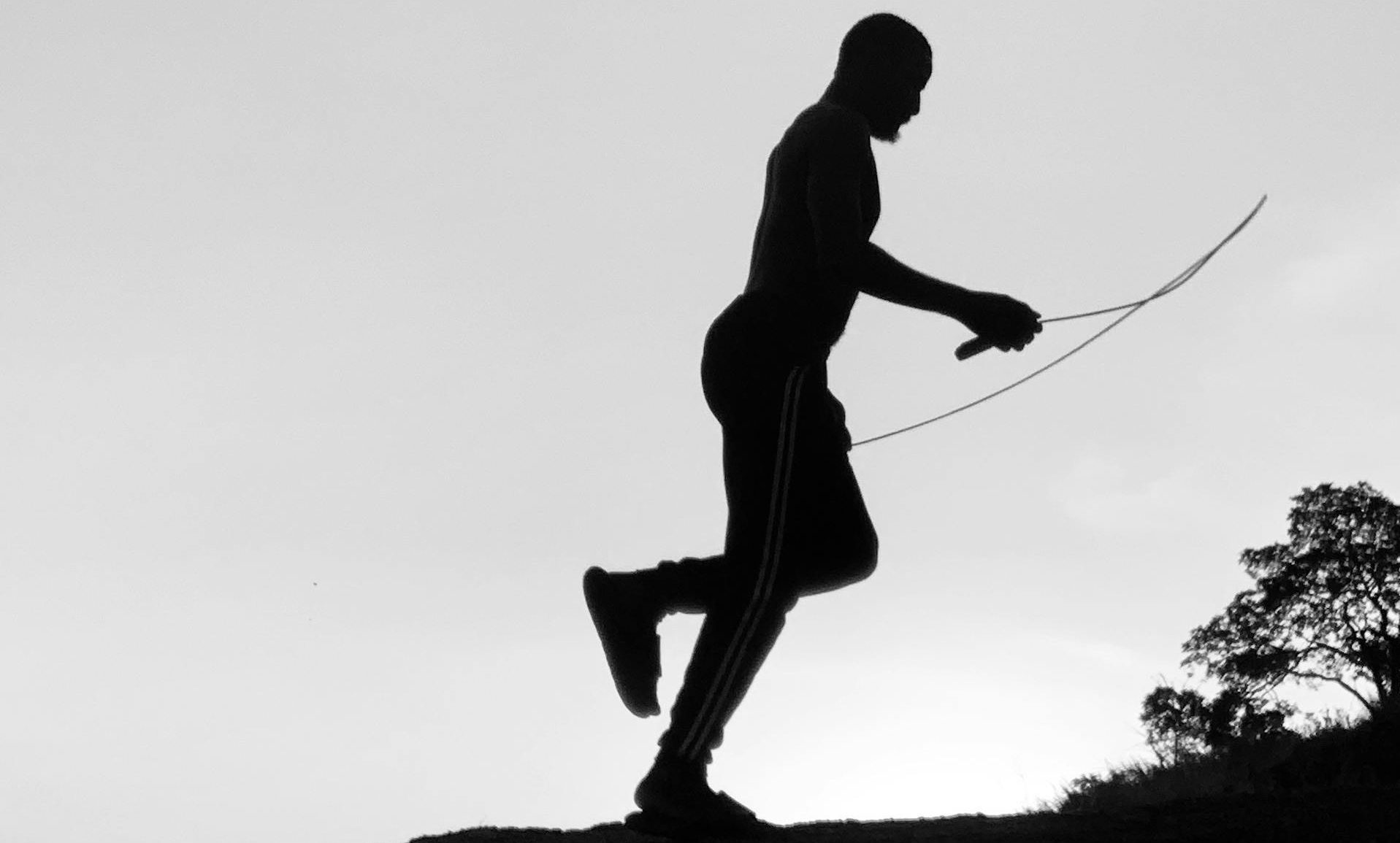 man skipping outside jumping rope