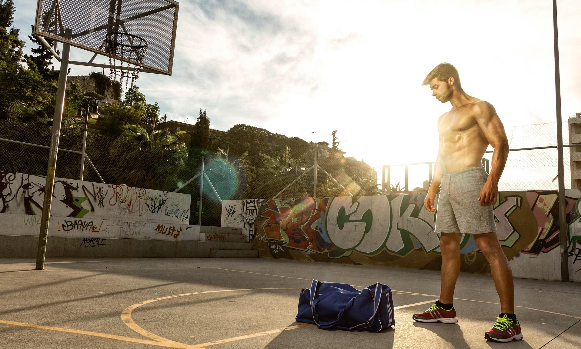 man outside by basketball court