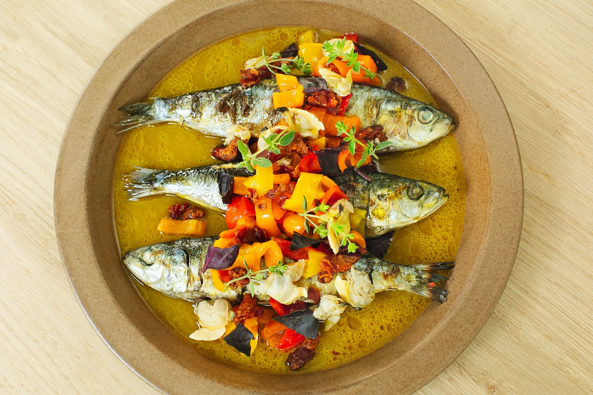three grilled sardines on round plate
